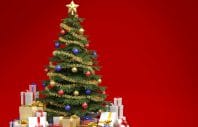 Fully decorated christmas tree with many presents isolated on red background with copy space on the right