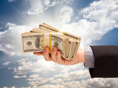 Male Hand Holding Stack of Cash Over Clouds and Sky